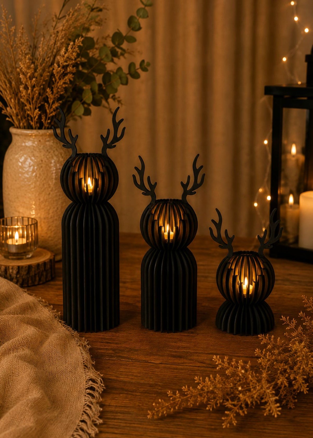 Drewniane świeczniki w kształcie renifera na tealight – trzy rozmiary, czarne, z płonącymi świeczkami LED